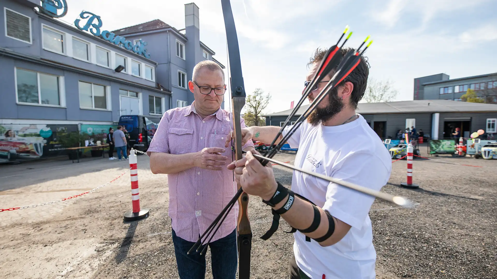 Konzentration beim Bogensport Trainer gibt einem Teilnehmer Hilfestellung beim Bogenschießen